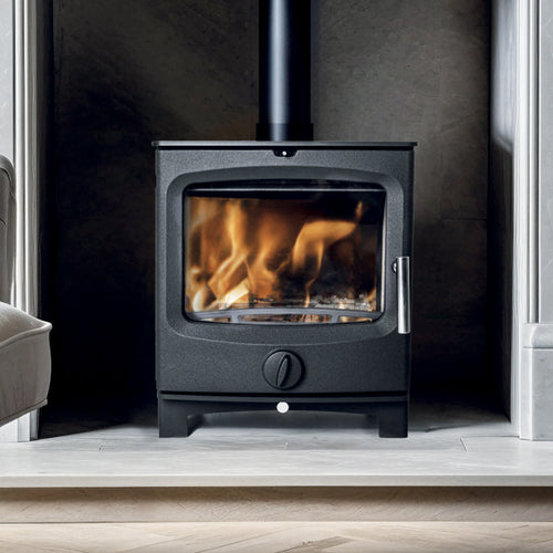 Close up of black Stubby 5 stove front view with active flames behind glass, polished steel handle, and circular air control